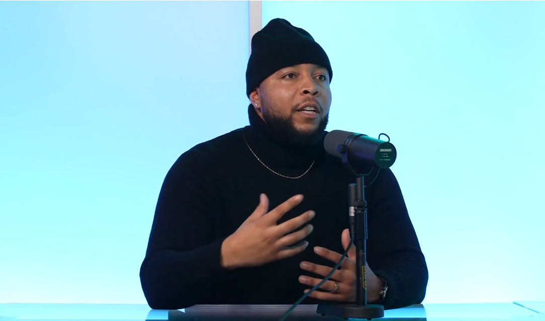 Mychael Anderson sharing his message at a podcast microphone